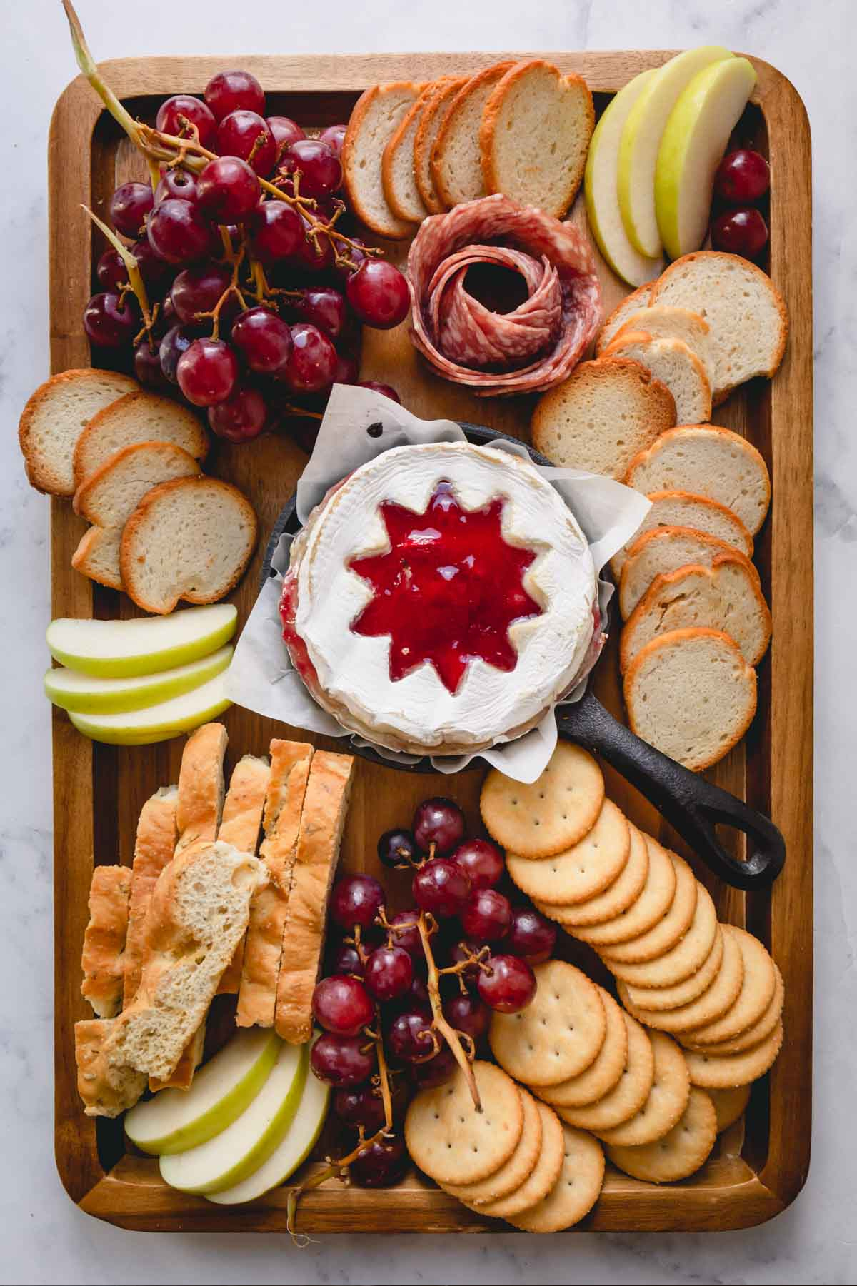 Fruit, bread, meat, grapes, and a brie wheel with jelly are shown on Sweet and Savory By Shinee's board.