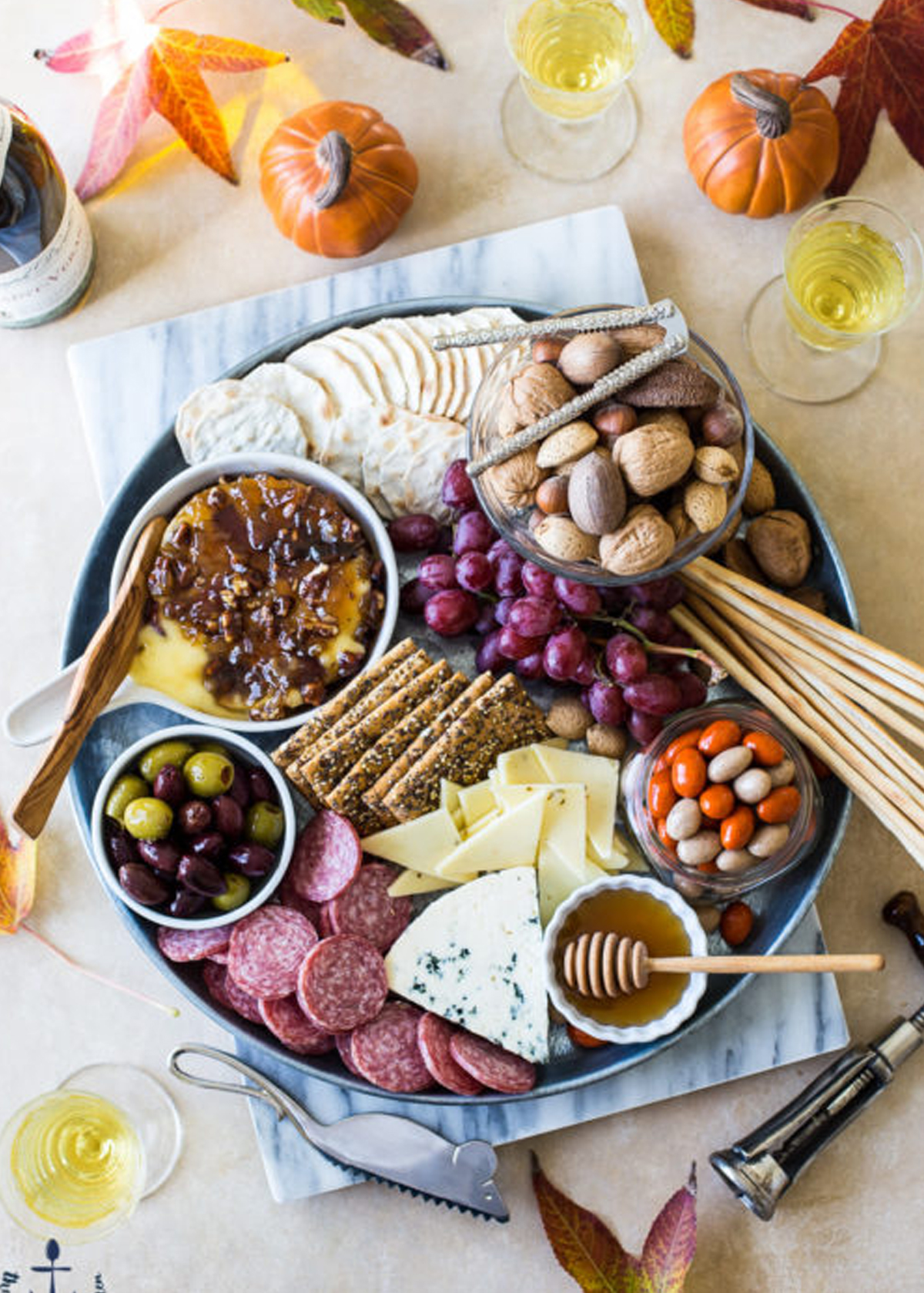 The Beach House Kitchen's board is full of brie, grapes, glazed pecans, crackers, bacon onion jam, and meat.