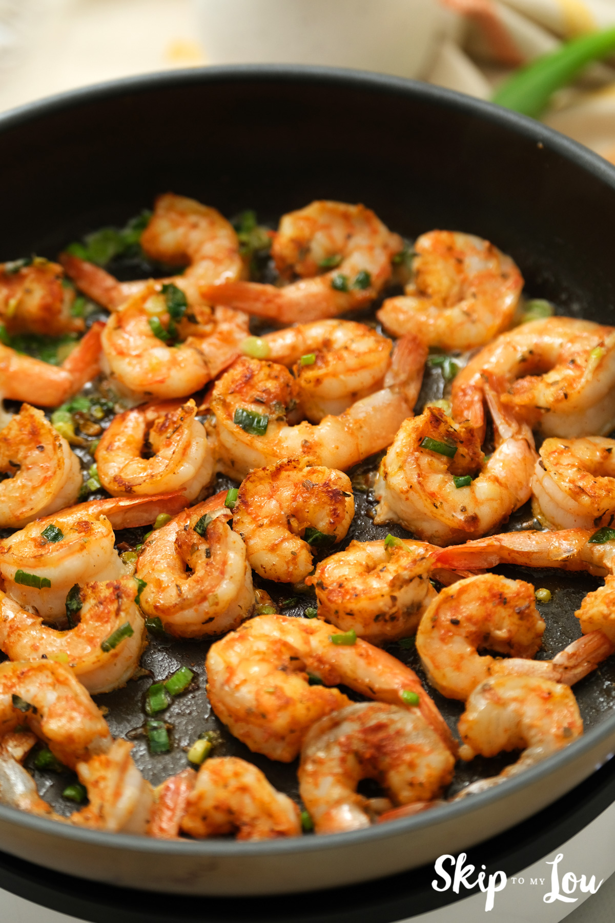 Fully cooked Cajun shrimp in a large skillet, by Skip to my Lou.