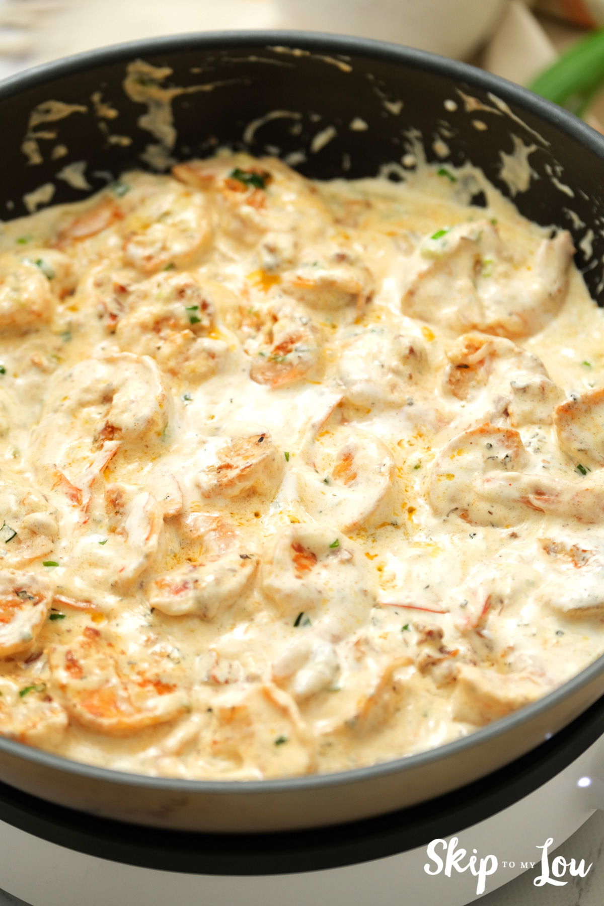 Cajun shrimp pasta with heavy cream and spices in a large skillet, by Skip to my Lou.