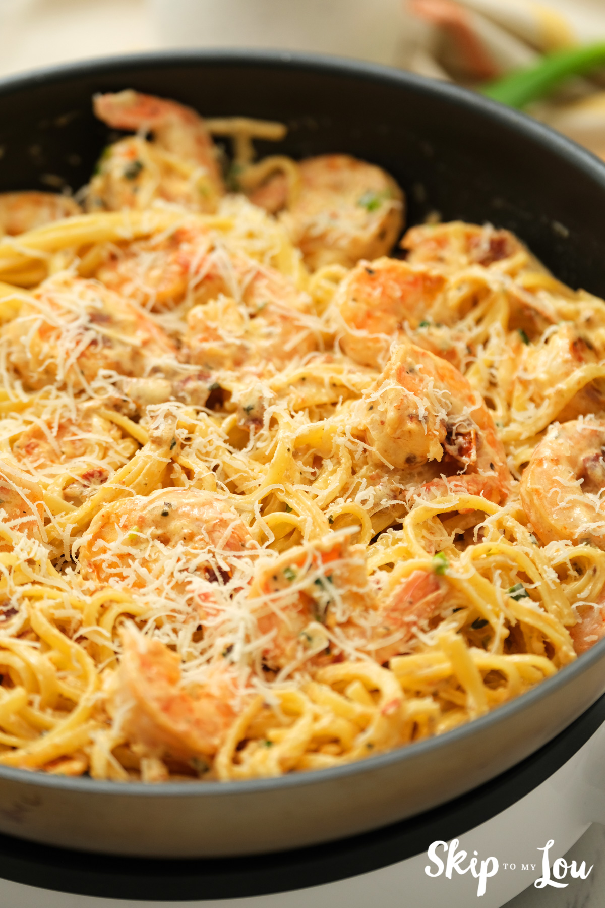Black skillet with Cajun shrimp pasta inside, by Skip to my Lou.