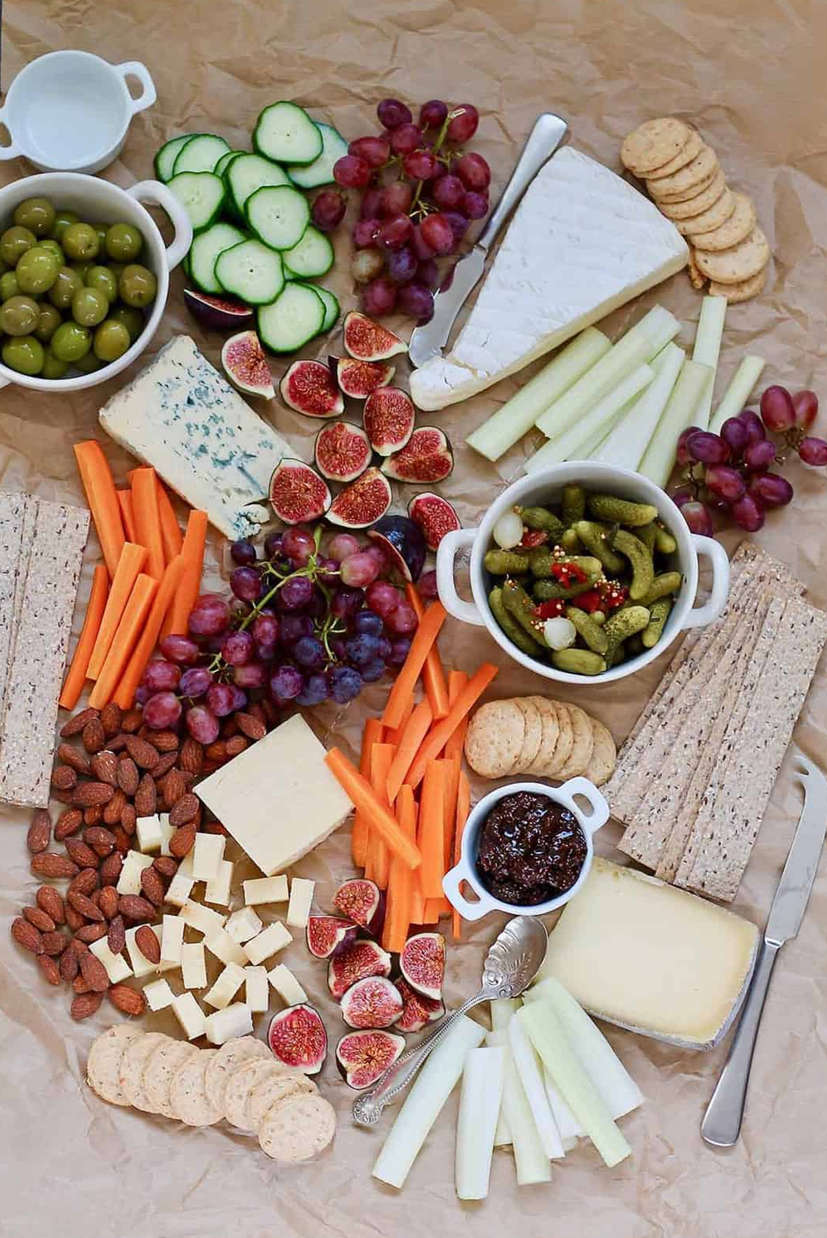 Hey Nutrition Lady presents a board full of cheese, cucumbers, pickles, carrots, and grapes.