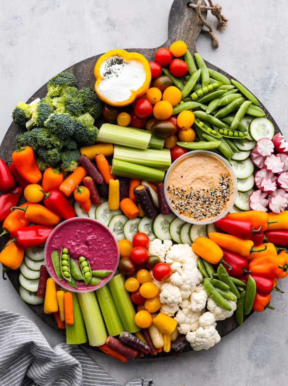 Recipe Critic displays an celery, peppers, broccoli, tomatoes, and dips on their veggie charcuterie board.