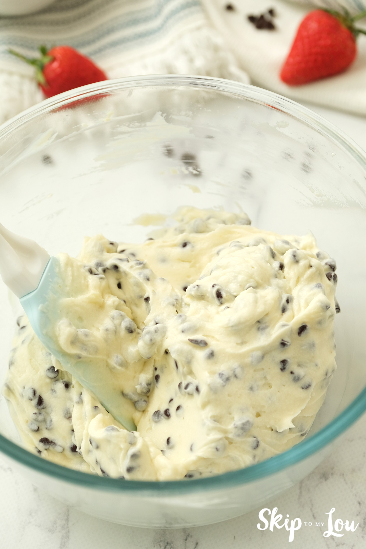 Spatula mixing chocolate chips into dip mixture, by Skip to my Lou.