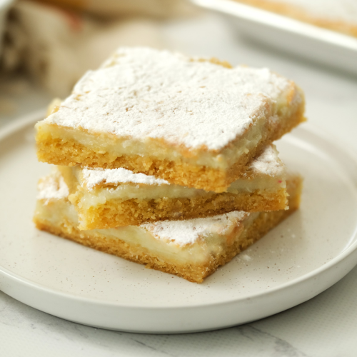Three gooey butter bars sitting on a white plate, by Skip to my Lou.