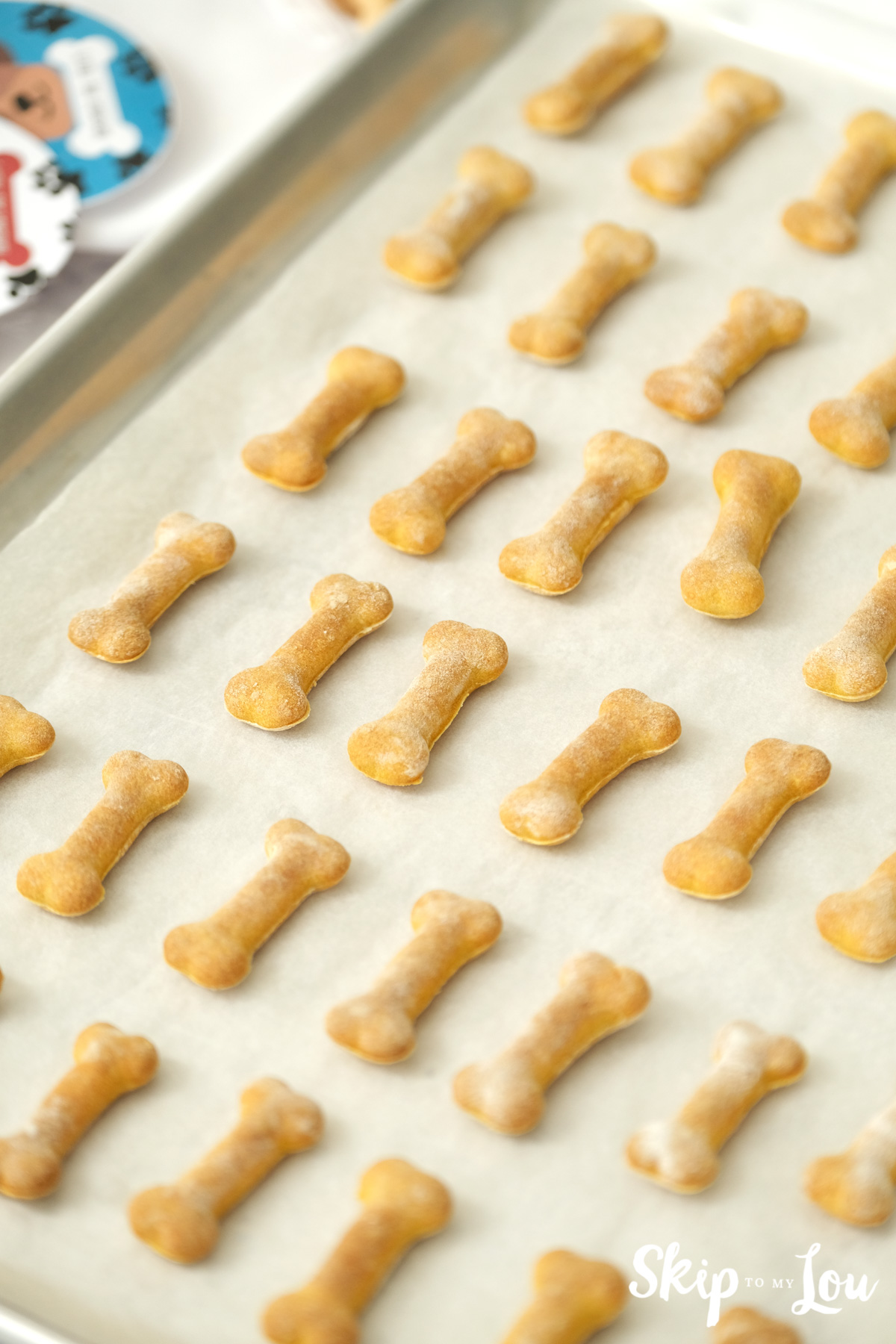 Baked dog biscuits on a silver baking sheet, by Skip to my Lou.