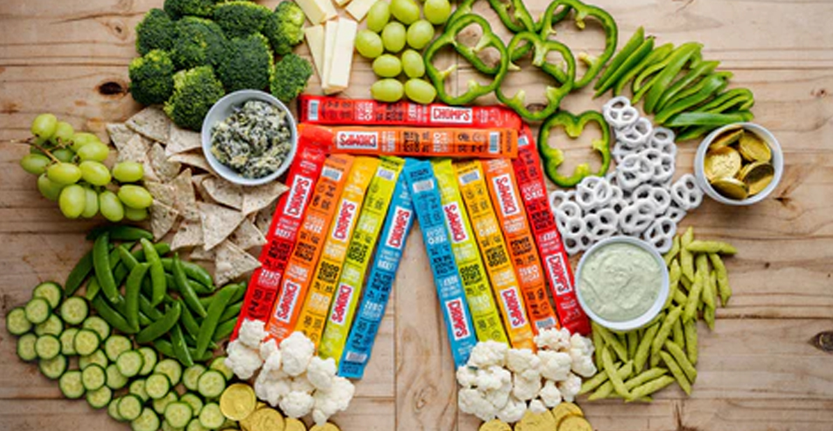Chomps uses their beef jerky packages to create a rainbow surrounded by green foods.