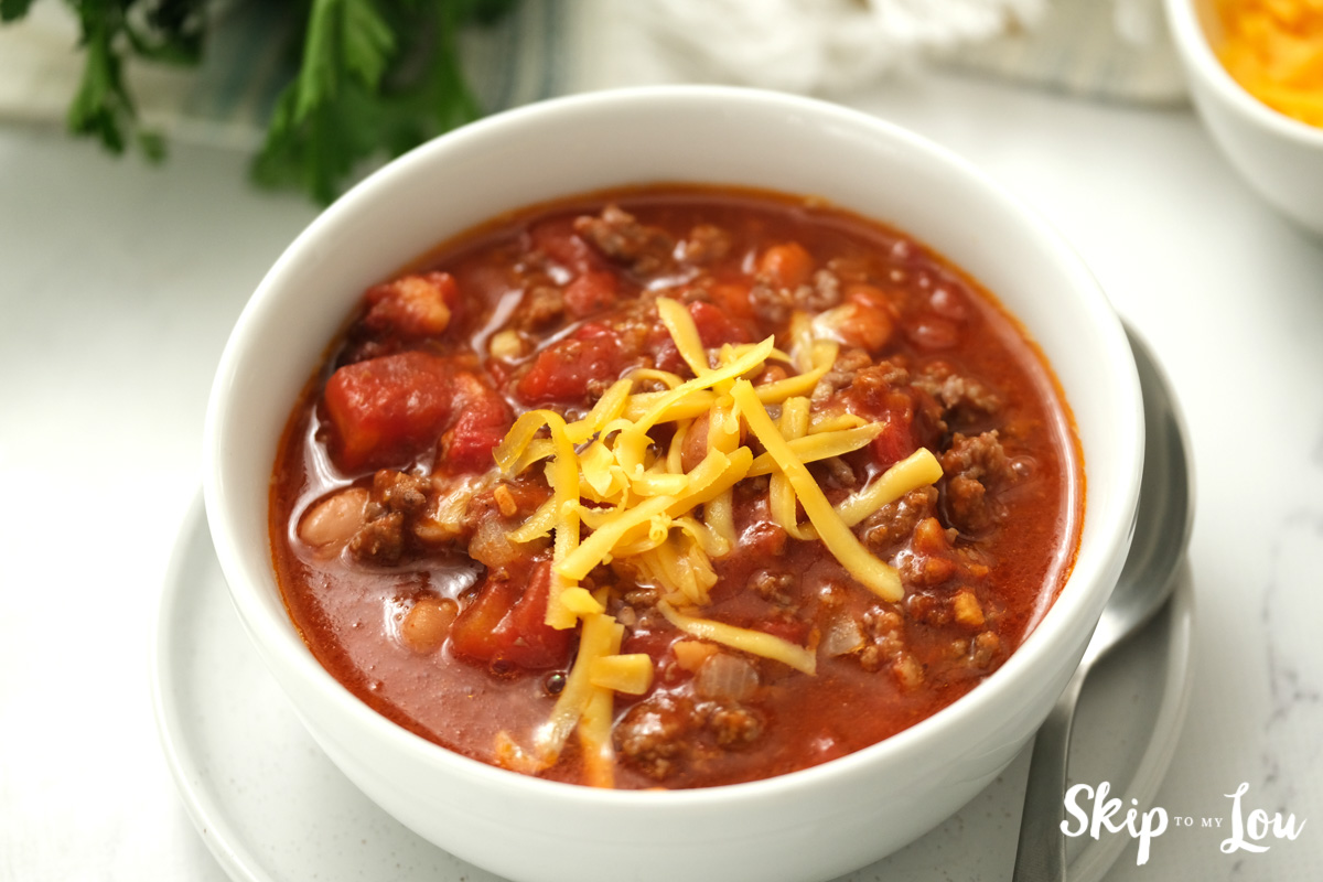 Slow cooker chili in a white bowl, by Skip to my Lou.