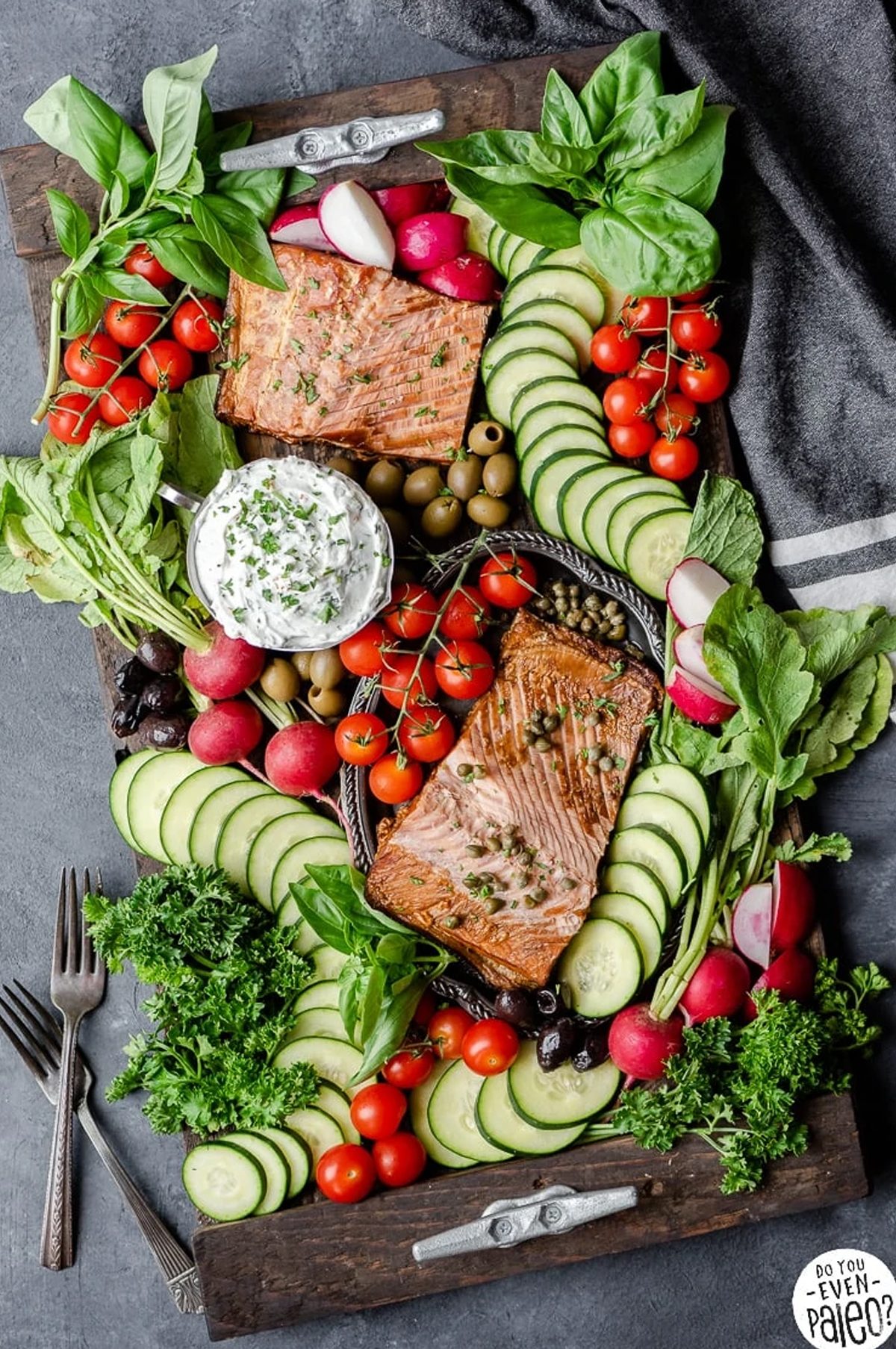 Smoked Salmon, goat cheese, veggies, and herbs are displayed on Chelsea Joy Eats board.
