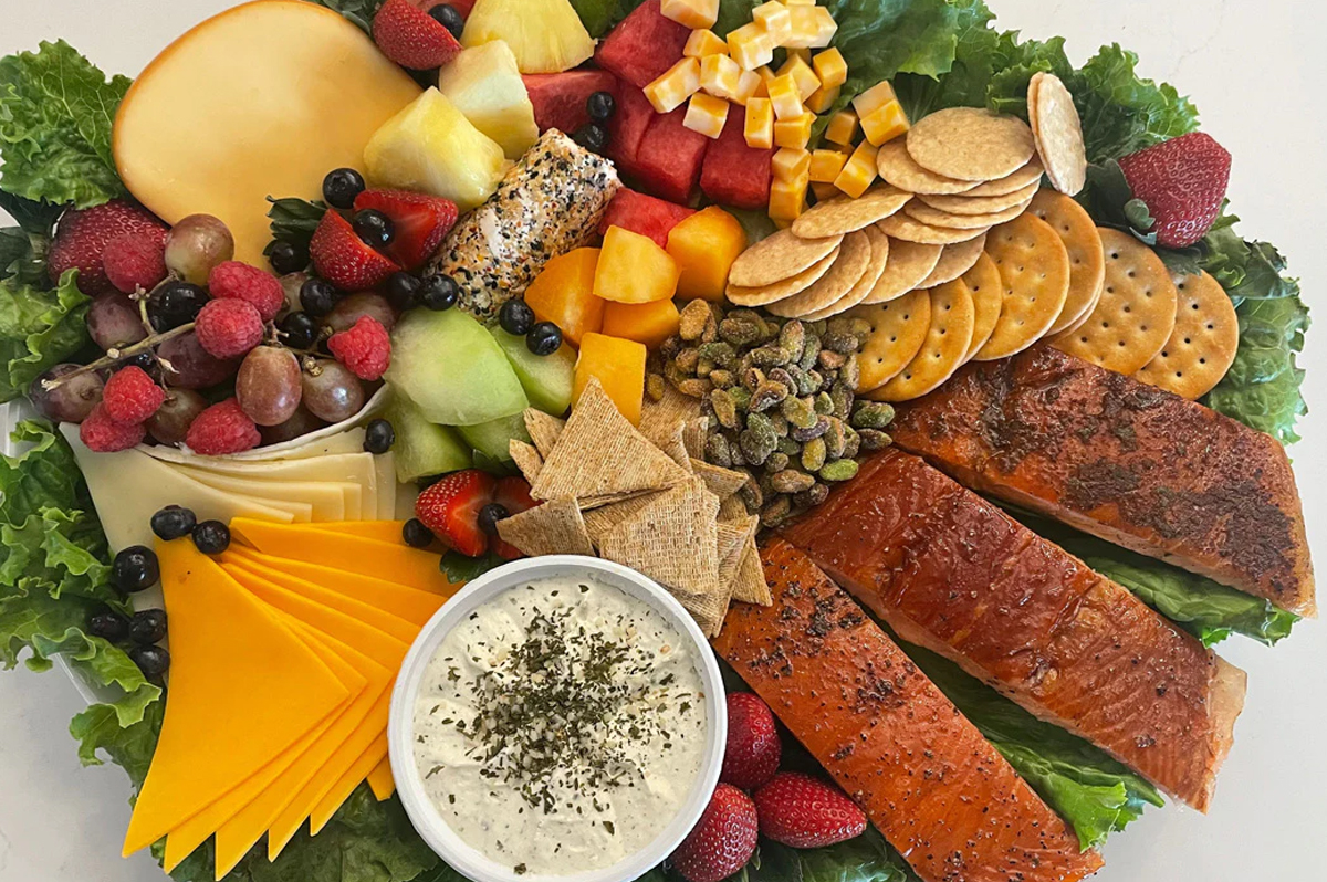Honey Smoked Fish Co.'s charcuterie board showcases sweet honey salmon, cheese, and crackers.