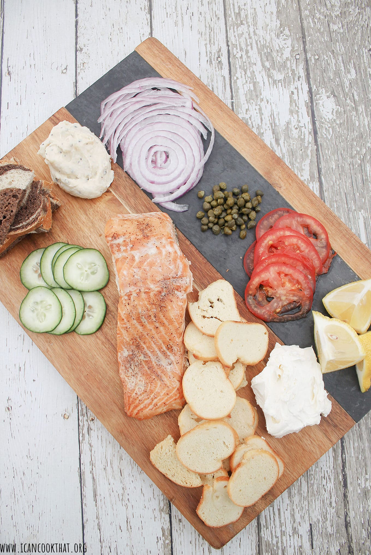 I Can Cook That 's board is full of onion, salmon, cucumber, lemon, and bagel chips.