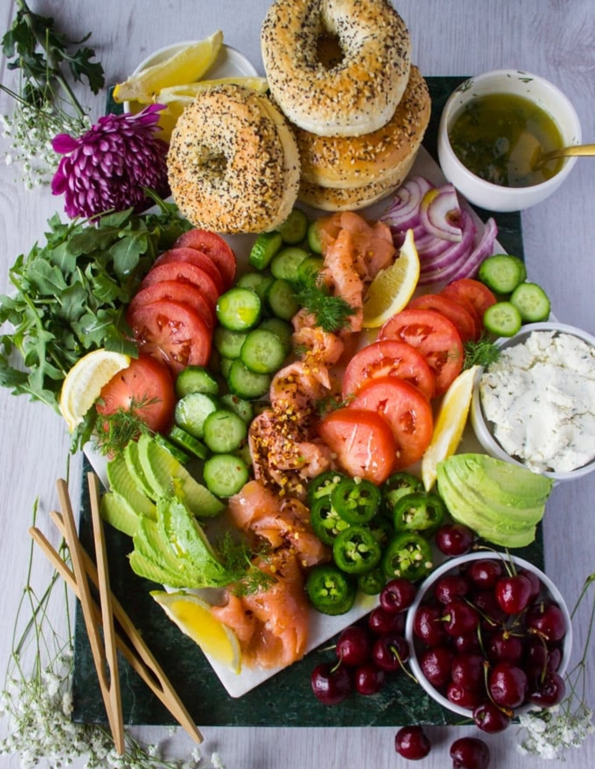 Bagels, tomatoes, dill, cucumbers, salmon, and cream cheese are included on Two Purple Figs charcuterie board.