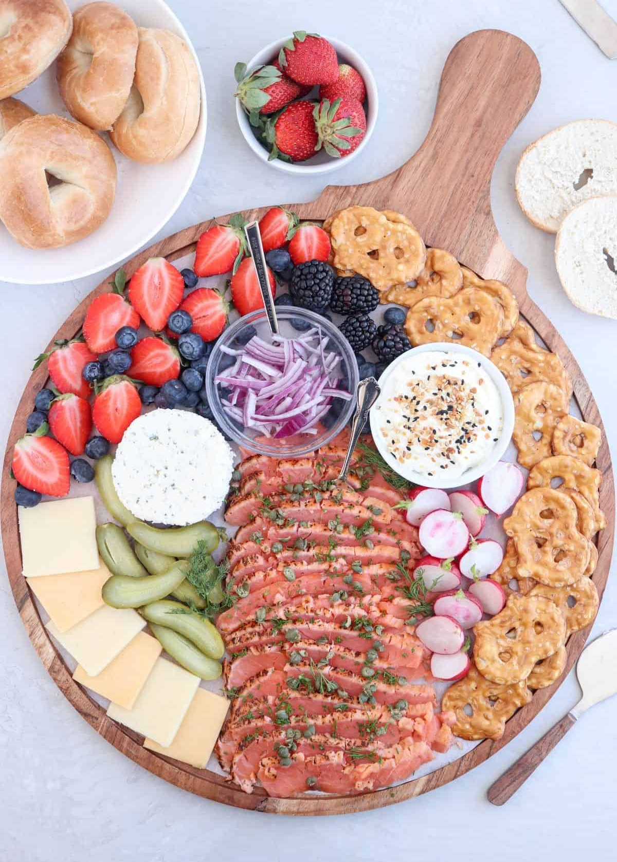 Wholly Tasteful's salmon board is filled with creamy cheese, strawberries, salmon, and berries.