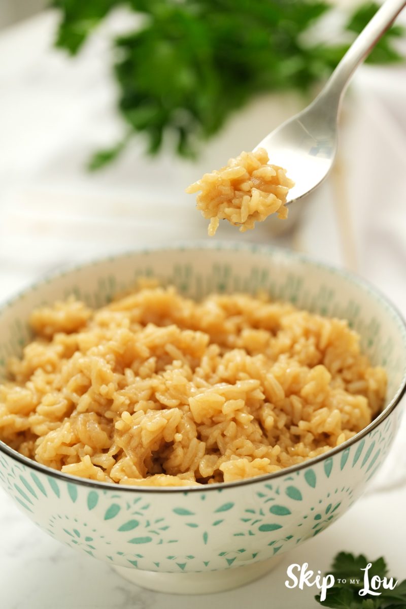 Fork full of rice served in a blue and white bowl, by Skip to my Lou.