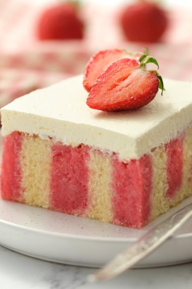 Red and White striped cake topped with smooth white icing and fresh strawberries, by Skip to my Lou.