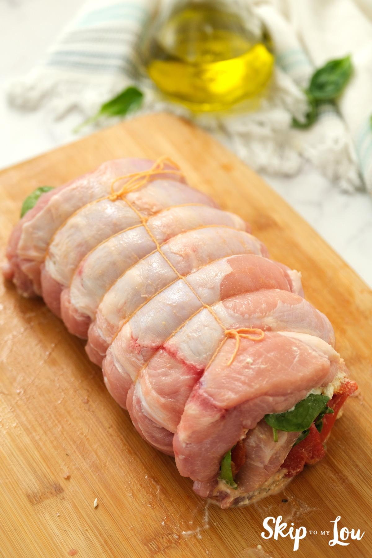 Stuffed pork loin secured with butcher's twine, by Skip to my Lou.