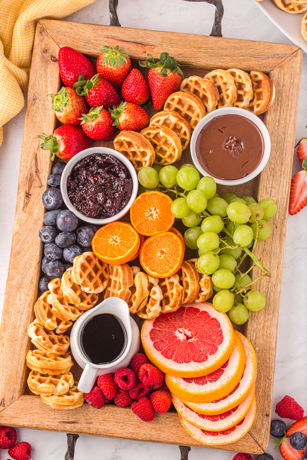 mini waffles, fruits, jams, and nutella fill this board from blackberry babe.