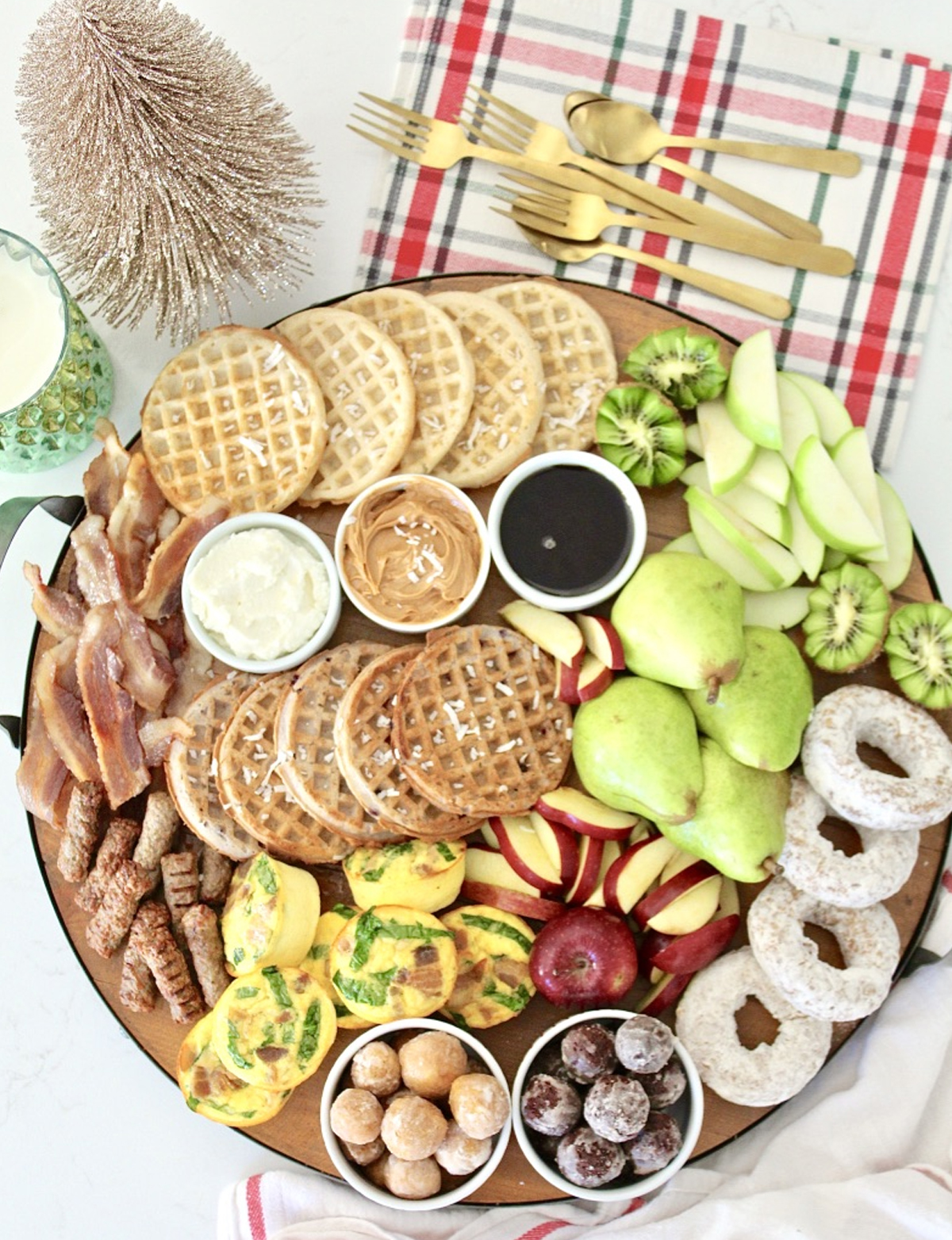 a holiday board with kiwi, egg bites, waffles, donuts and more from milk and honey nutrition.