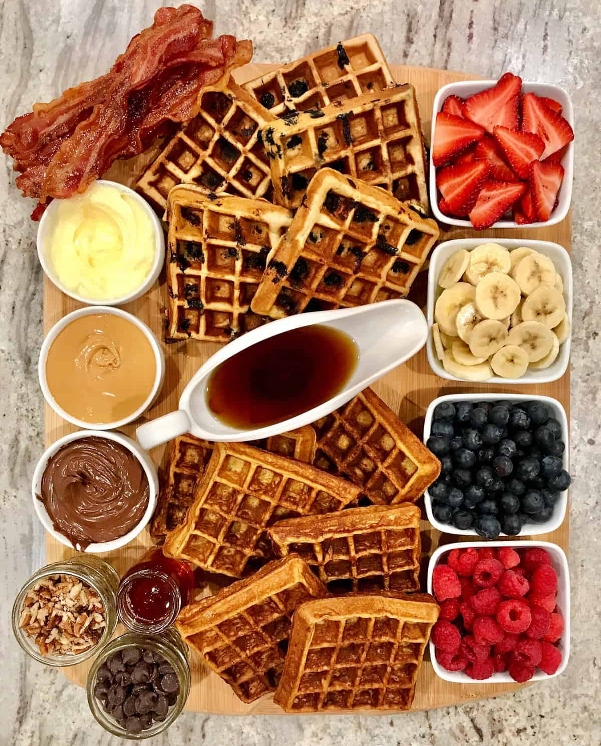 a variety of waffles and toppings from the bakermama including fruit, peanut butter, syrup, and more.