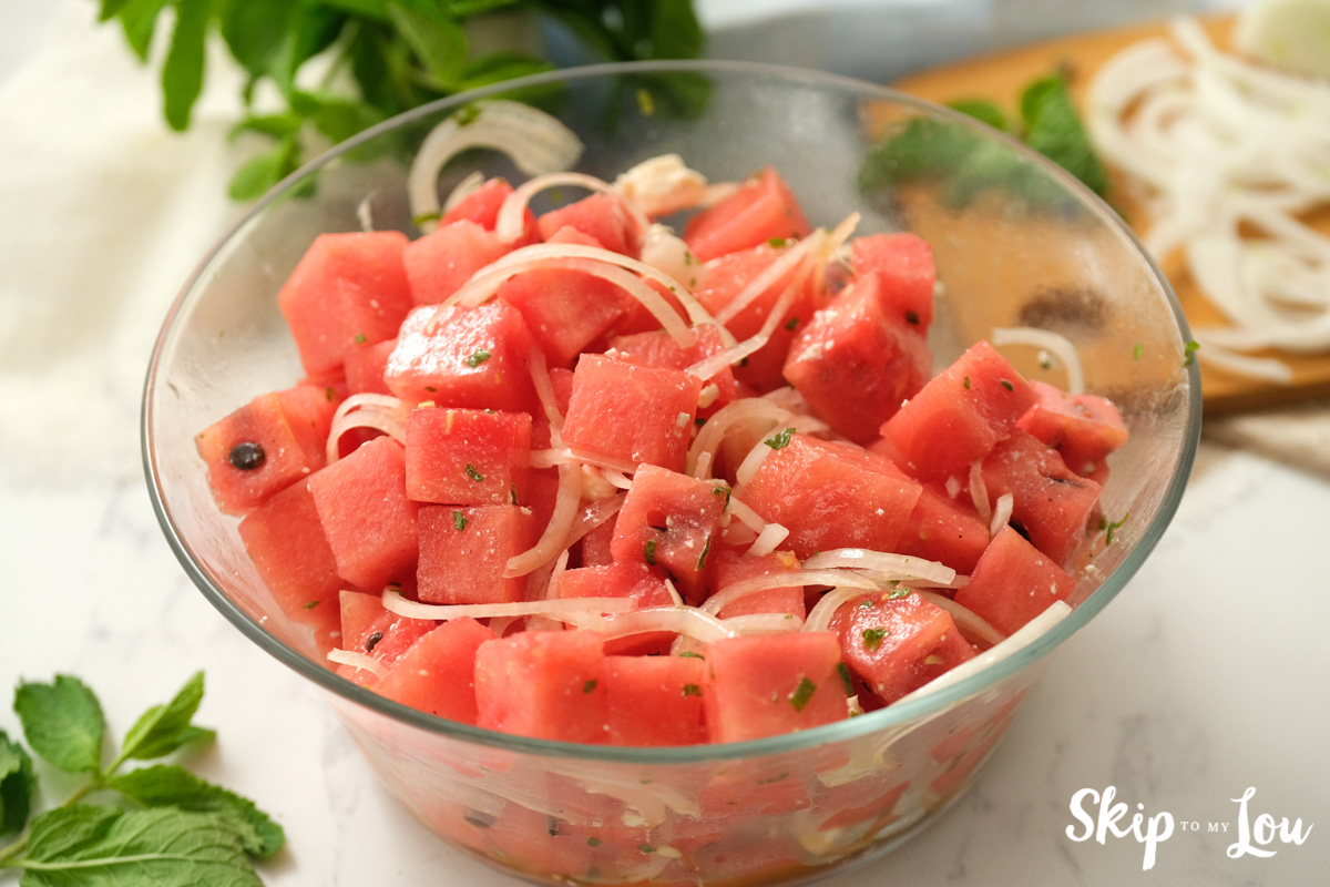 Watermelon salad in a clear glass salad bowl, by Skip to my Lou.