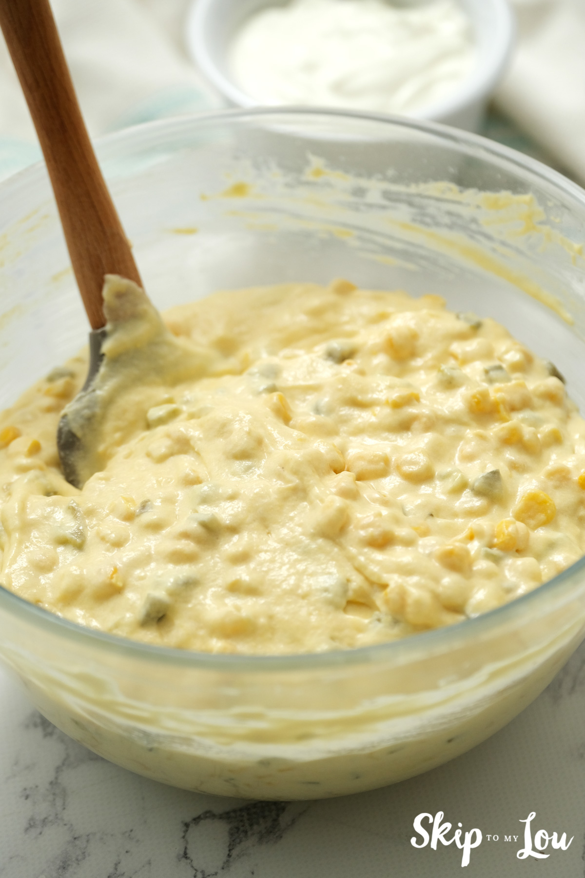 Ingredients for World's Best Cornbread in a clear glass mixing bowl, by Skip to my Lou.