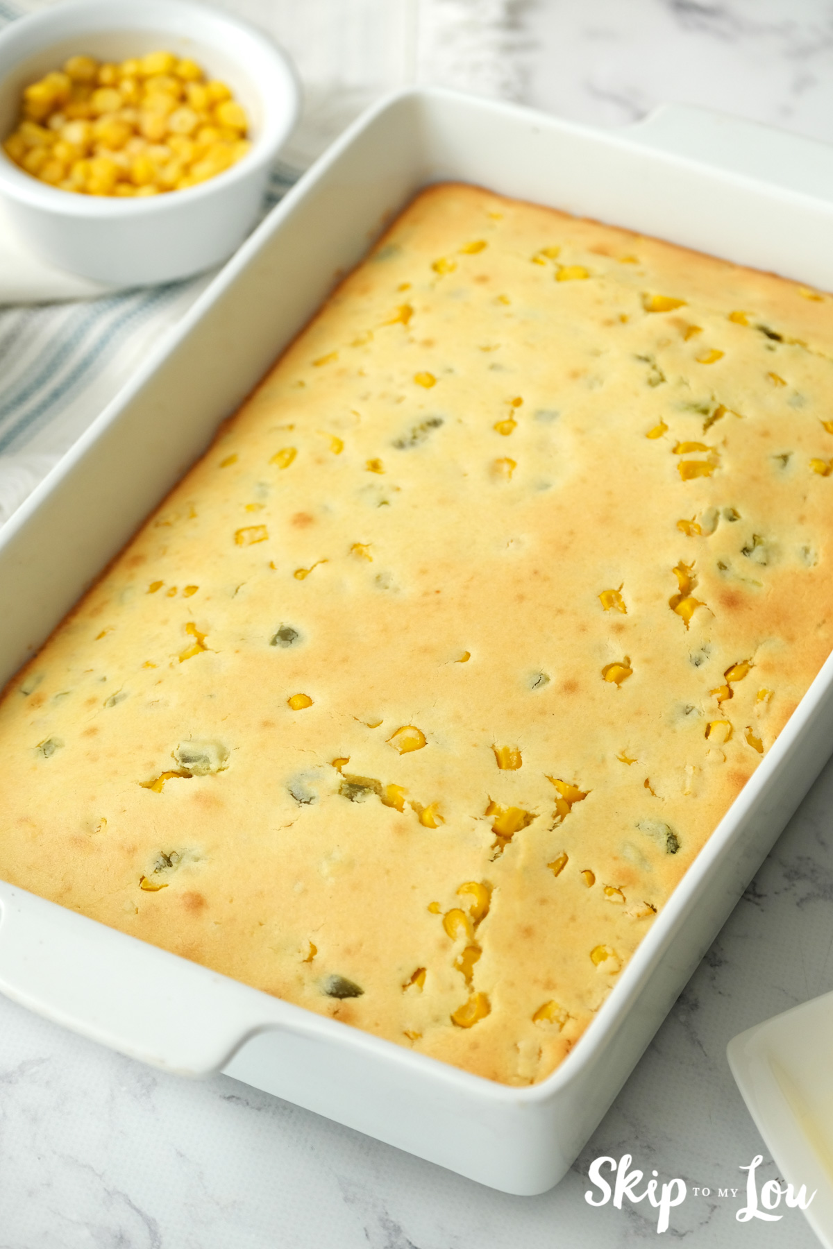 A white 9x13 baking pan with World's Best Cornbread inside, by Skip to my Lou.