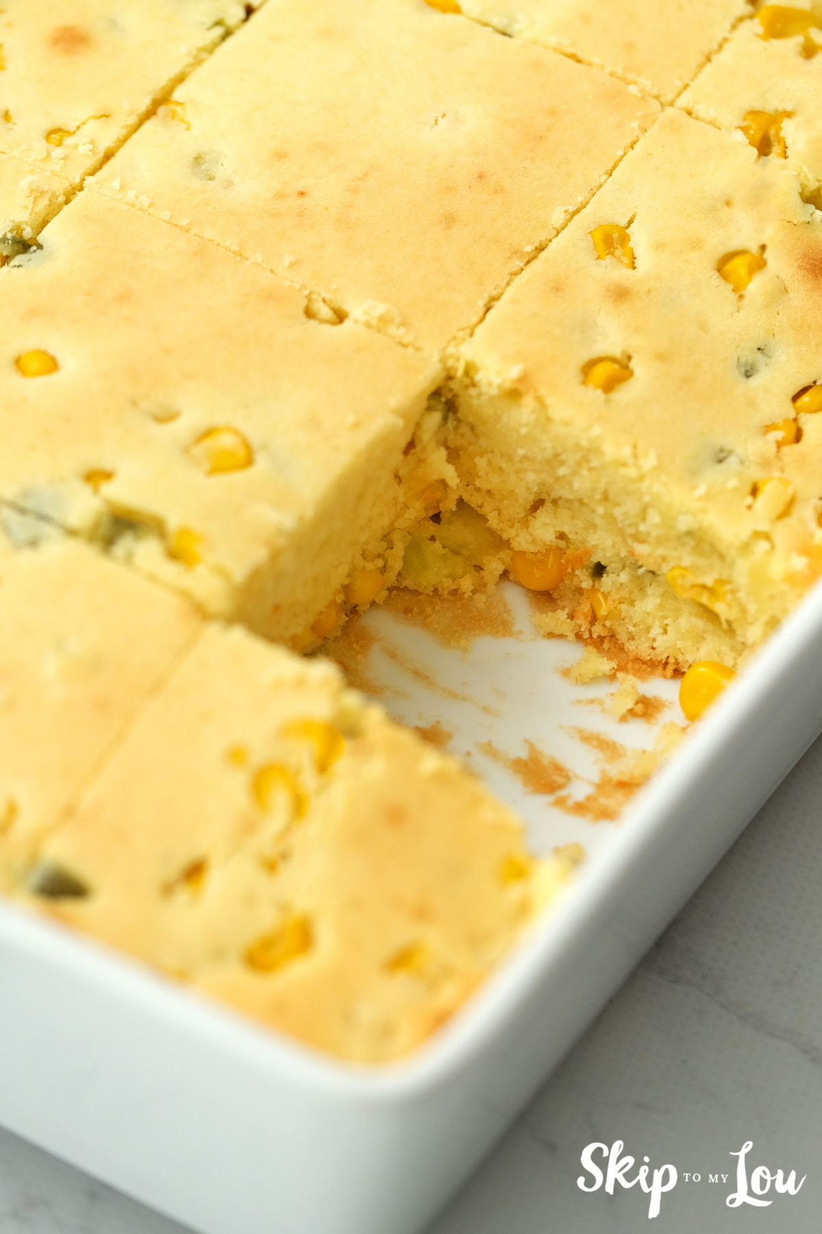 White baking dish with one square of World's Best Cornbread missing, by Skip to my Lou.