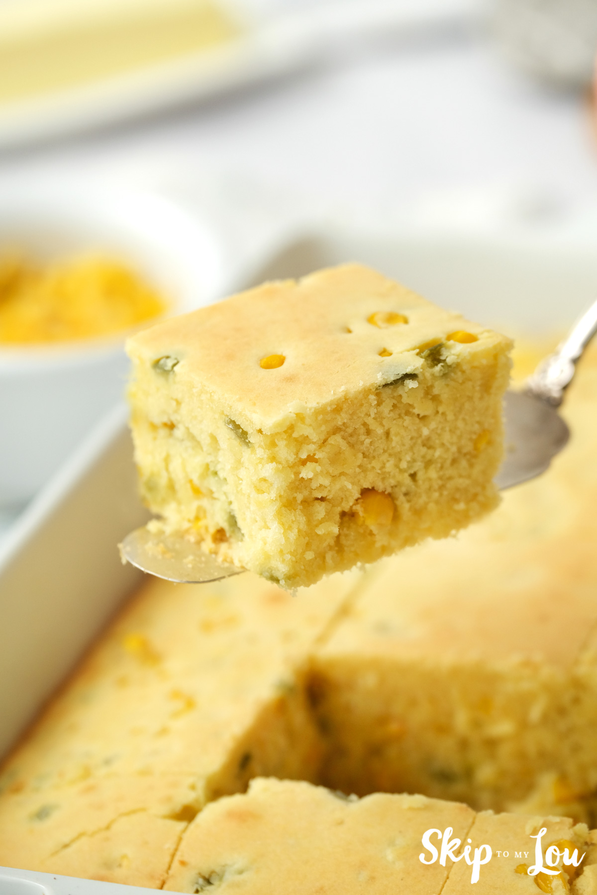 One square cube of cornbread on a silver serving utensil, by Skip to my Lou.