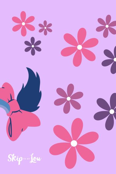 Image shows a donkey tail that resembels Eeeyore's tail, from Winnie the Pooh. It has some flower decorations around it and a pink-purple background. From Skip to my Lou