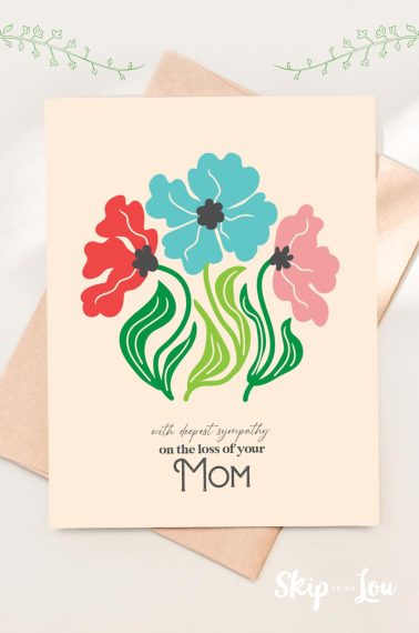 Printed mom sympathy card decorated with flowers, placed on top of a pink envelope.