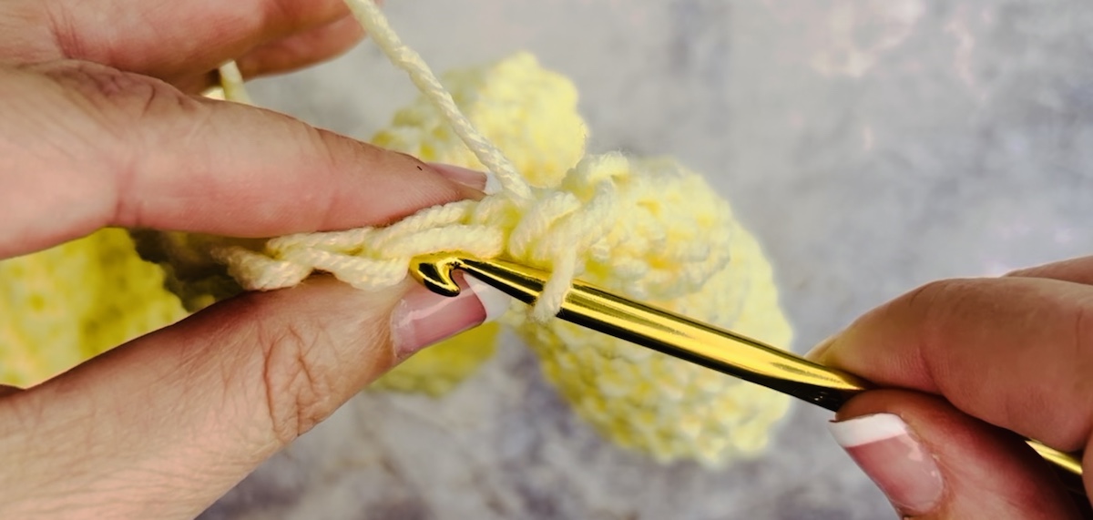 Step 3 to make a stitch crochet. Wrap the yarn over your hook from back to front, creating a loop around the hook.