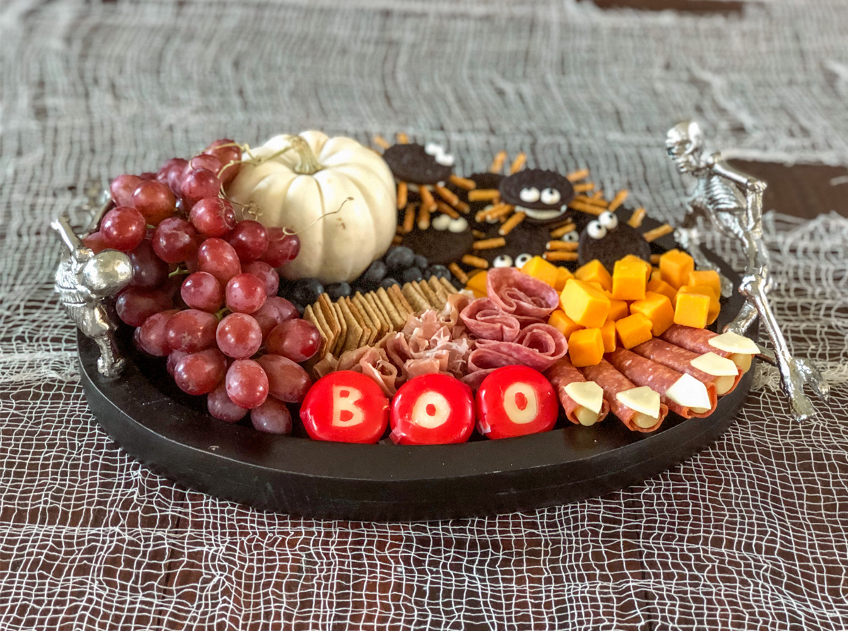 Cold cuts, a pumpkin, cheese and fruits fill Growing Up Bilinguals's Halloween Board.