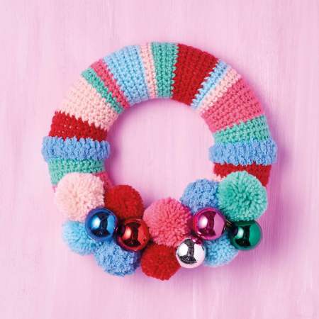 colorful crochet wreath with yarn pom poms