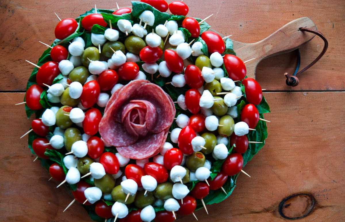 Mozzarella cheese, tomatoes, olives, and meat fill Amazing Charcuterie boards.