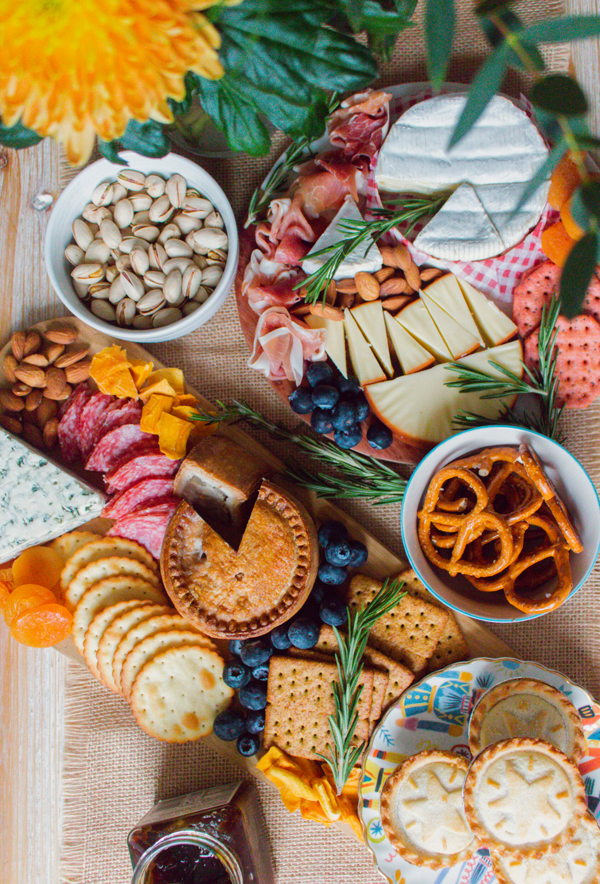 Soft and hard cheese, meats, nuts, crackers, pretzels, and dried fruit fill An Edited Lifestyles winter board.