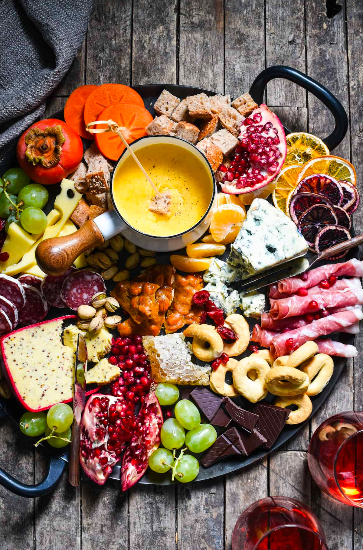 Chocolate, pomegranate, cheese, grapes, meat, bread, and seasonal fruit are included on Foxes Love Lemons' Winter cheese board. 