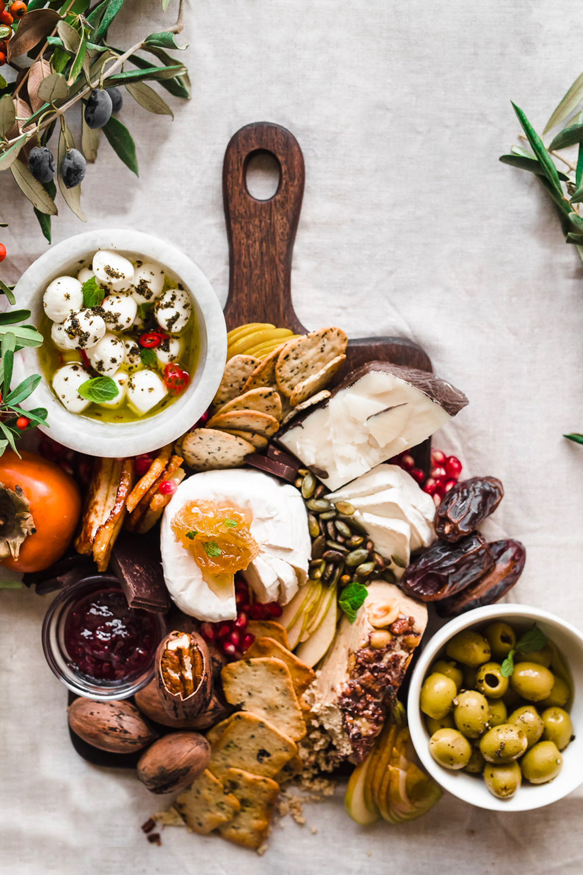 Gather A Table's holiday board includes seasonal fruit, chocolate, olives, cheese, and crackers.