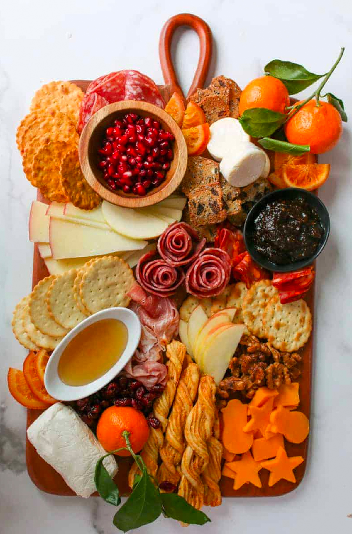 Make with Mara's winter board includes pomegranates, meat. cheese, clementine's, and crackers.