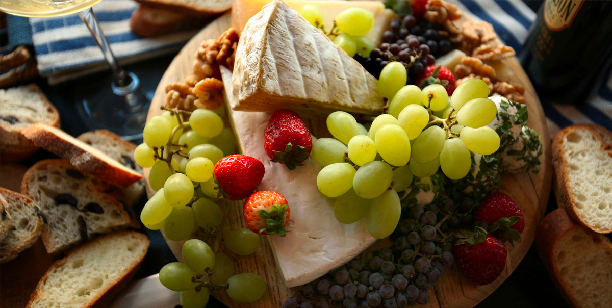 Meal Garden's board includes grapes, blueberries, strawberries, cheese, and bread.