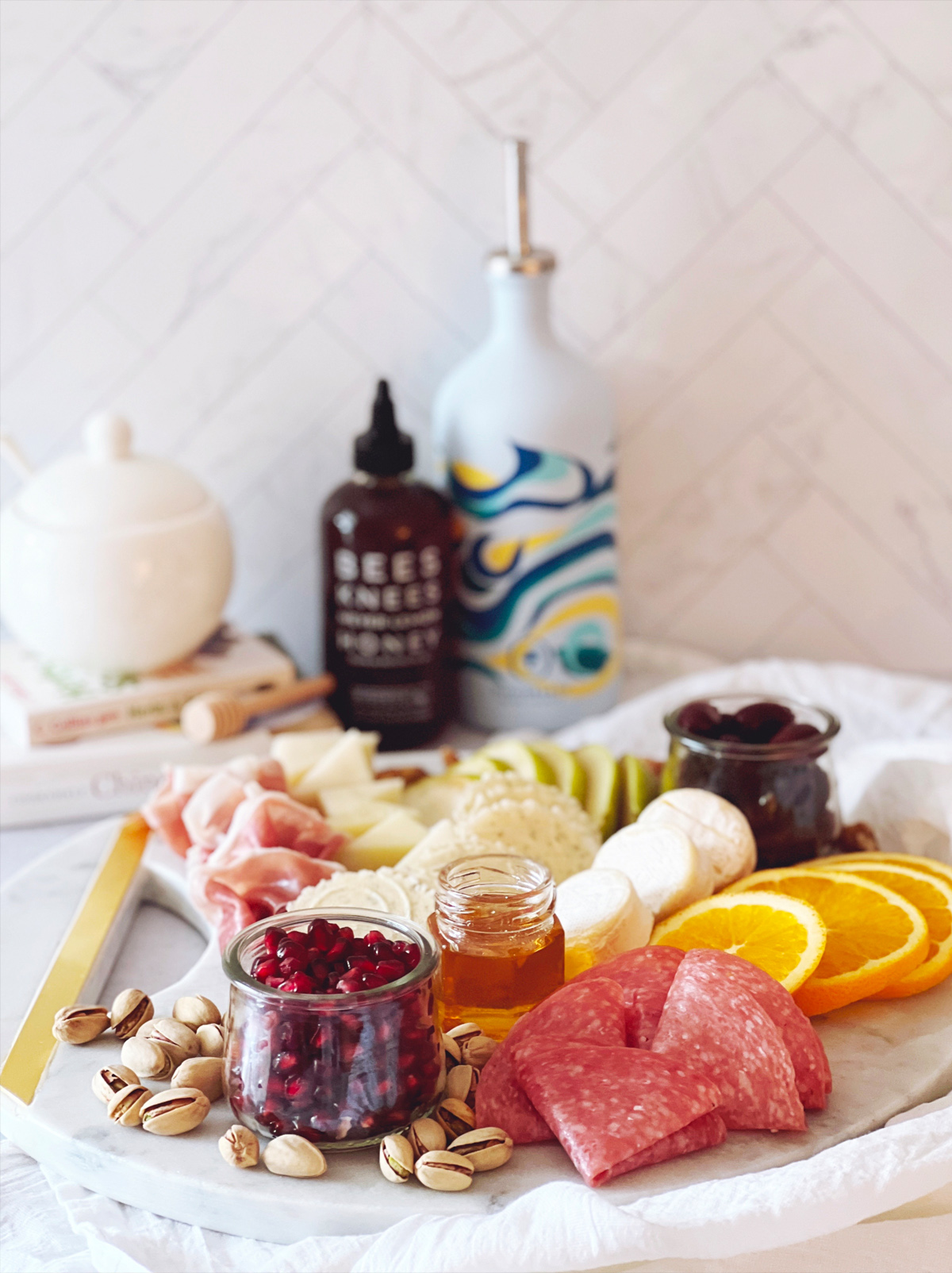 The Avid Pen's board is filled with cheese, meat, pomegranates, oranges, and nuts.