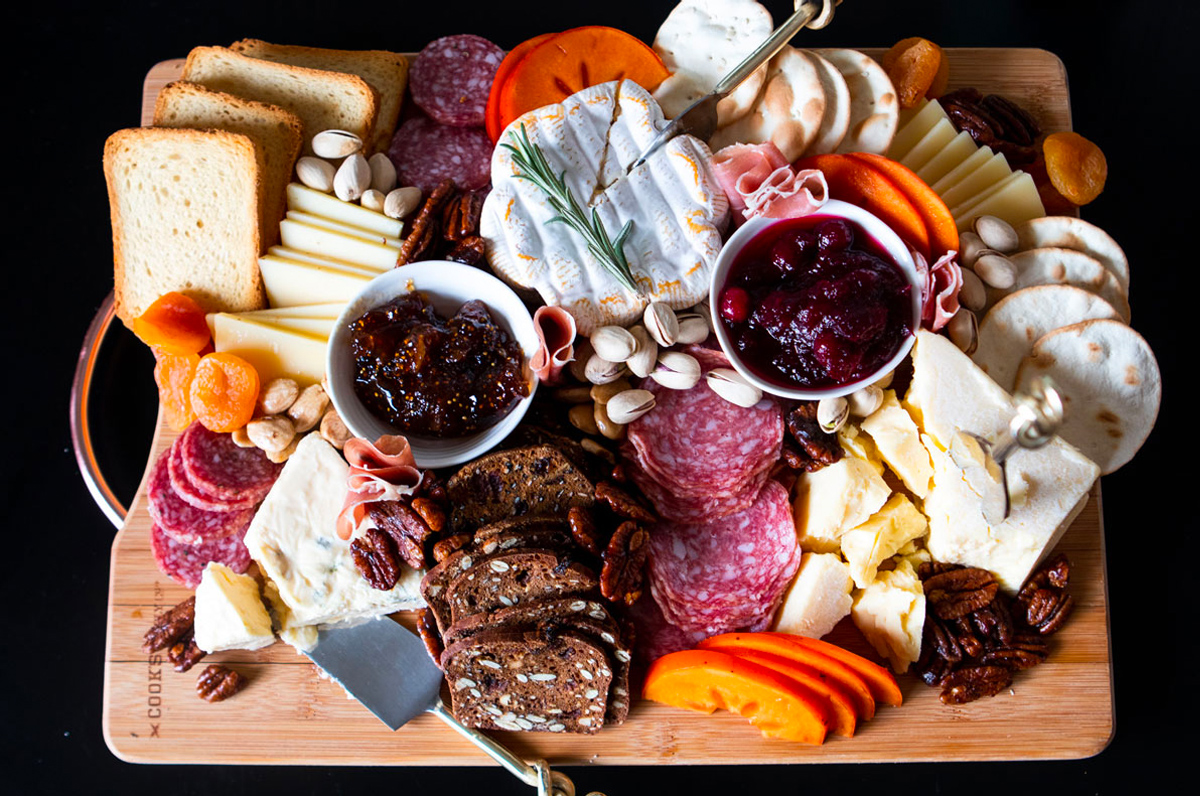 Cheese, meats, fig jam, dried fruit, nuts, bread, and crackers are included on The Fancy Pants Kitchen's winter charcuterie board.