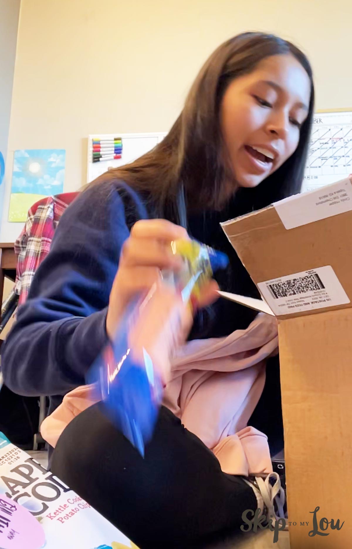 an excited college student opening an exam care packaging