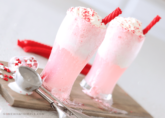 two pink and white cupid sundaes with red licorice straws