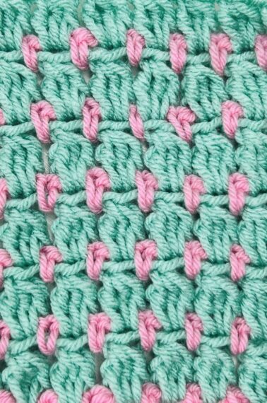 A light pink and mint green swatch of cluster crochet stitching.