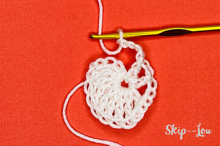 White yarn crocheted into a circle on an orange background.
