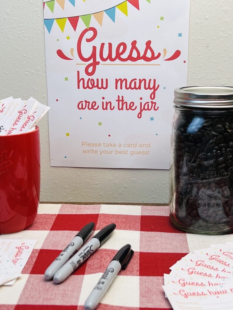 guess how many in the jar sign with a mason jar full of roasted coffee beans, pens and cards for making guesses
