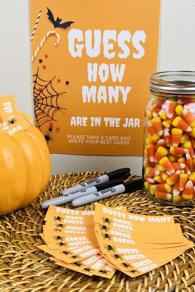 guess how many in the jar sign with a mason jar of candy corns, pens and cards for making guesses