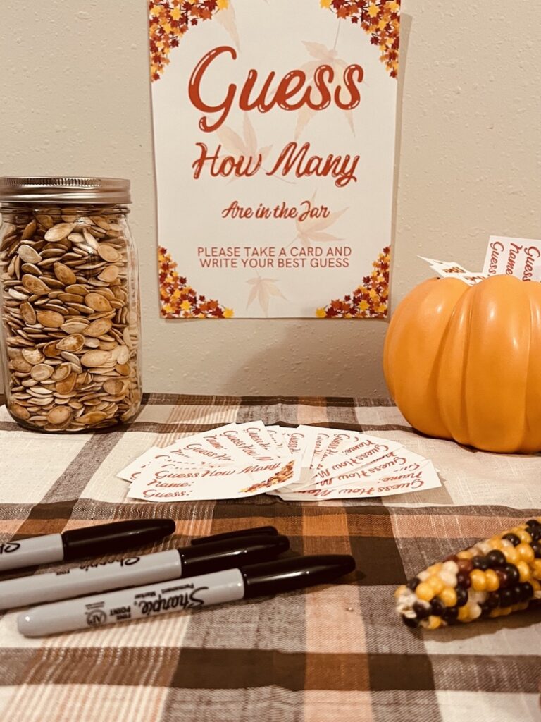 guess how many in the jar sign with a mason jar full of pumpkin seeds, pens and cards for making guesses