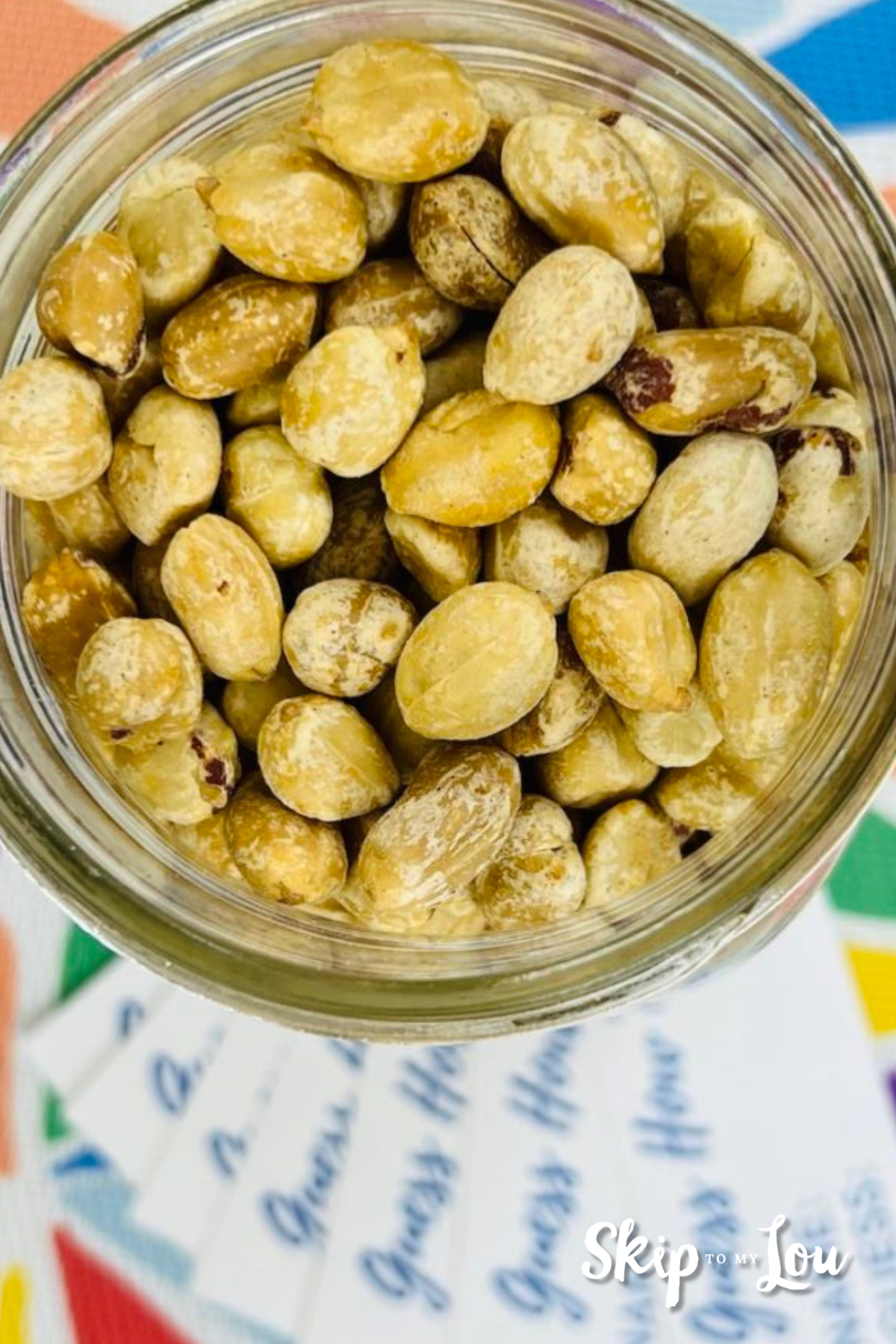A mason jar, photographed from above, sitting on cards where you can place your guess, and filled with peanuts.