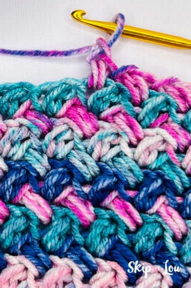 Crochet sample of the mini bean stitch in varying shades of pink and blue.